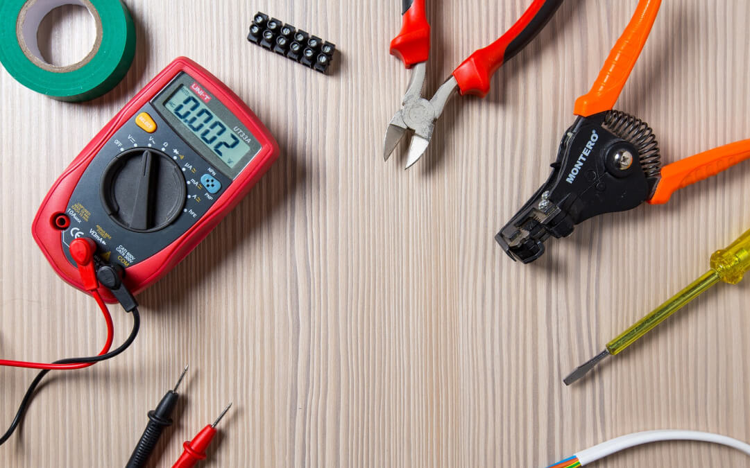 Electrical tools on a table, including pliers and wire cutters, commonly used by DCEA's emergency electrician for urgent repairs