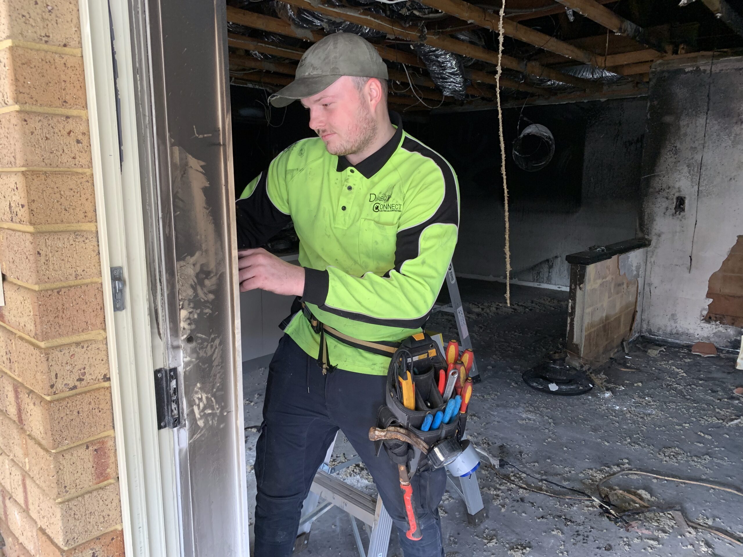 An emergency electrician with tools in hand performing urgent repair services inside a residential home